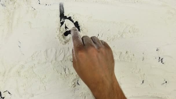 Young man writes a word bon appetit on white flour — Stock Video