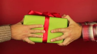 Genç adam, kırmızı zemin üzerine bir hediye verir. Yeşil hediye kutusu ile kırmızı kurdele açma. Mutlu yıllar, mutlu yıllar, mutlu Sevgililer günü, hediye Hediyeler tebrik