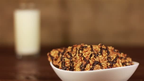 Vaso de leche y galletas en plato sobre una mesa de madera y fondo marrón — Vídeos de Stock