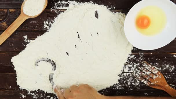 Top view Young man writes a word number 2017 on white flour at wooden desk from above. — Stock Video