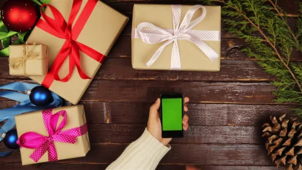 Top view hands using mobile phone touchscreen multi touch gestures green screen on christmas wooden table — Αρχείο Βίντεο