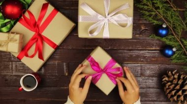Üstten Görünüm eller yukarıda ahşap masa çıkartıyorum Noel hediyeleri