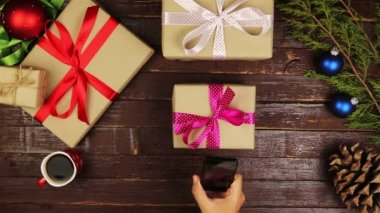 Üstten Görünüm adam Noel süsleri Smartphone Noel hediyeleri tablosunu yukarıdan kullanarak fotoğraf çekme