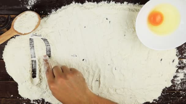 Vista dall'alto Giovane uomo scrive una ricetta di parole sulla farina bianca alla scrivania di legno dall'alto . — Video Stock