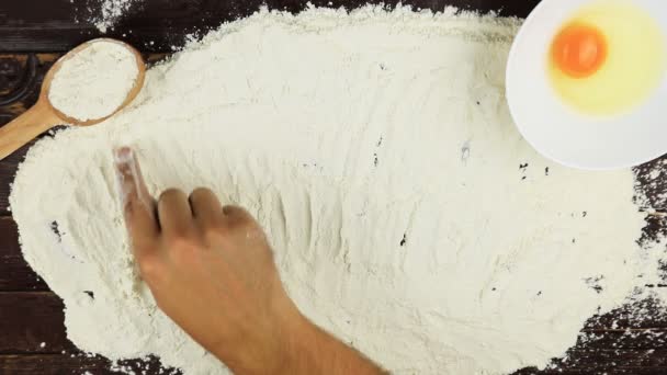 Top view Young man writes a word bread on white flour at wooden desk from above. — Stock Video
