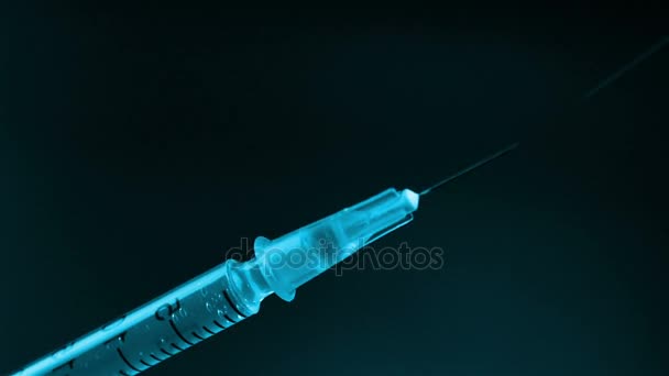 Spraying medicine from the syringe before injection on black background — Stock Video