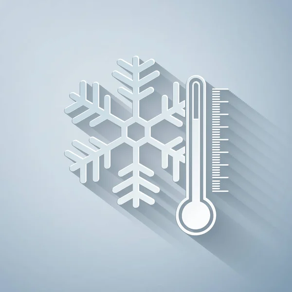 Papier gesneden thermometer met sneeuwvlokje pictogram geïsoleerd op grijze achtergrond. Papierkunst stijl. Vector Illustratie — Stockvector