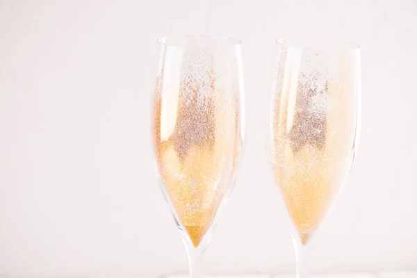 Gold sparkling dust in champagne glasses.