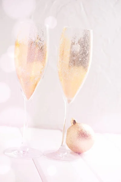 Gold sparkling dust in champagne glasses.