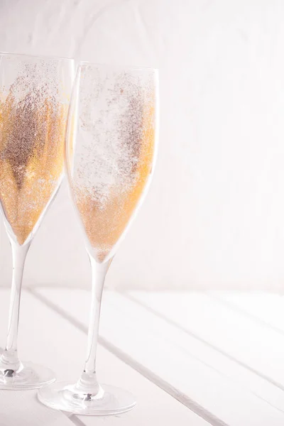 Gold sparkling dust in champagne glasses.