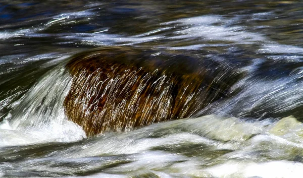 Agua que fluye sobre una roca — Foto de Stock