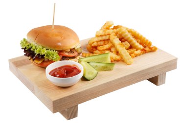 Hamburger patates kızartması ile soslu ve salatalık ile beyaz bir arka plan üzerinde bir gemide