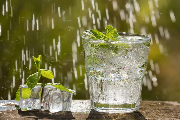 A glass of soda water on an old board, on the nature — Stock Photo, Image