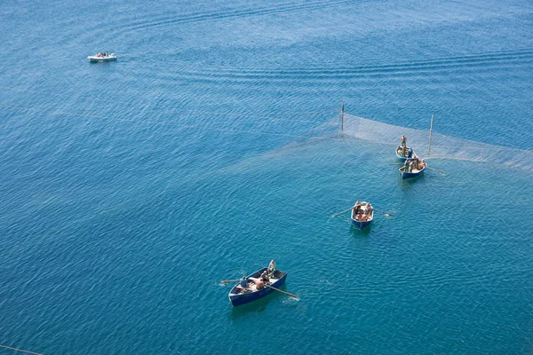 Рибалки на човнах в блакитному морі перевіряють мережу, вид зверху — стокове фото