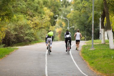 iki bicyclists ile parkta yürüyüş sırt çantaları