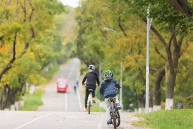 bir genç, bir çocuk ve onun anne Bisiklete binmek