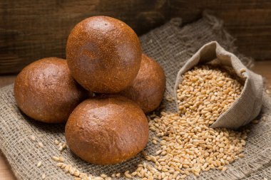 buğday taneleri ve kulaklardan oluşan bir çanta ile bir kompozisyon içinde beş taze iştah açıcı rulo