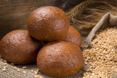 buğday taneleri ve kulaklardan oluşan bir çanta ile bir kompozisyon içinde beş taze iştah açıcı rulo