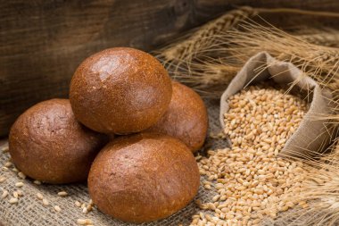 buğday taneleri ve kulaklardan oluşan bir çanta ile bir kompozisyon içinde beş taze iştah açıcı rulo