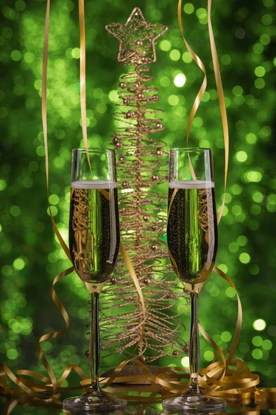 Två glas champagne med gröna bokeh bakgrund, festlig dekoration, jul leksaker — Stockfoto