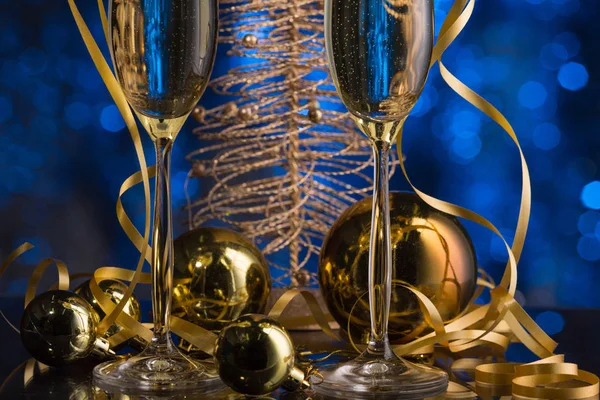 Två glas champagne med en blå bokeh bakgrund, festlig dekoration, jul leksaker — Stockfoto