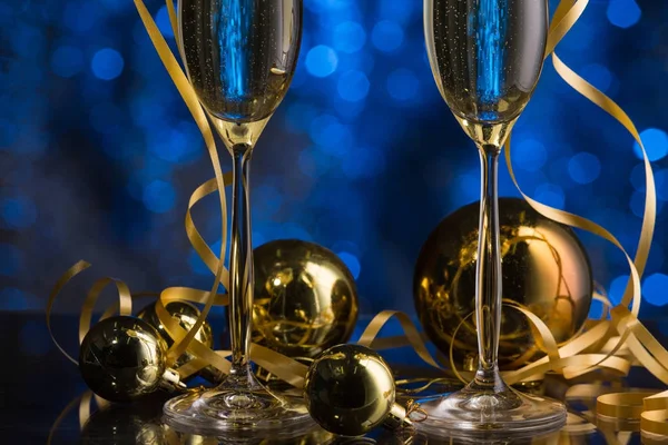 Två glas champagne med en blå bokeh bakgrund, festlig dekoration, jul leksaker — Stockfoto