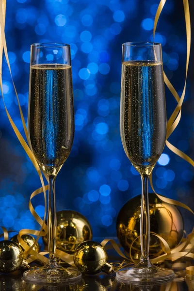 Två glas champagne med en blå bokeh bakgrund, festlig dekoration, jul leksaker — Stockfoto