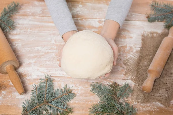 Eller bir kızın bir tahta masa, oklava, bir tabloda bir Noel ağacının dalları üzerinde hamur yoğurma — Stok fotoğraf