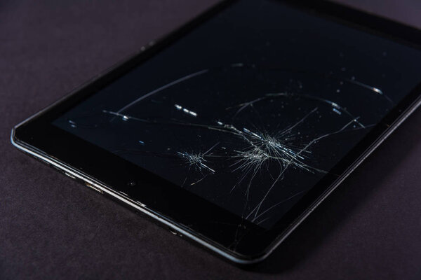 Image with broken display of a smartphone or tablet computer on black background.