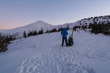 Ukrayna Karpatları 'nın karlı kış dağlarında akşam zirvelerinin güzel manzaralı turistleri..