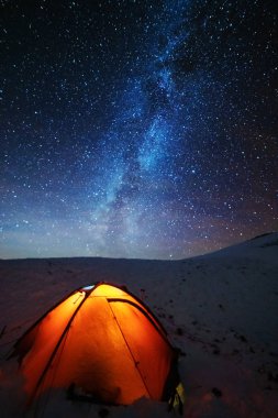 Kışın peri masalı Karpat Dağları gökyüzünde büyüleyici bir samanyolu vadilerde turist çadırları ve karlı evler