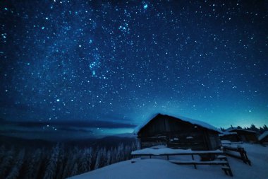Kışın peri masalı Karpat Dağları gökyüzünde büyüleyici bir samanyolu vadilerde turist çadırları ve karlı evler