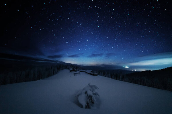 Сказочные пейзажи зимних Карпат с очаровательным молочным путем в небе туристические палатки и снежные дома в долинах
