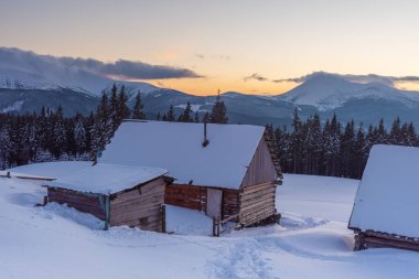 Karpatlar 'da bir dağ vadisinde karla kaplı büyüleyici evler, kışın muhteşem zirveler..