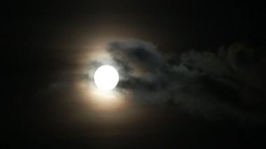 Ay ve bulutlar gökyüzünde hızla süzülür.