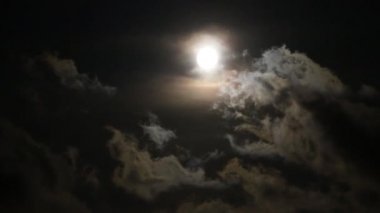 Ay ve bulutlar gökyüzünde hızla süzülür.