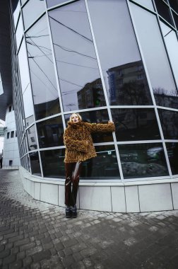 Sokakta poz veren, sahte kürklü güzel bir kadın.