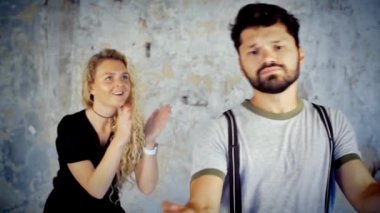 Adam kamera önünde dans ediyor. Mutlu genç çift aşık eğleniyor müzik dinlerken yavaş dans.