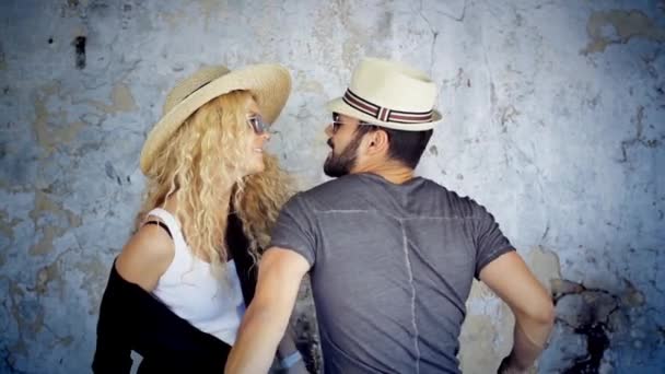 Happy young couple in sunglasses and hats dancing in slow motion listening to music having fun in love. — Stock Video