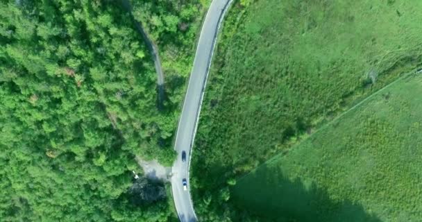 Cámara aérea grabada a lo largo de la carretera concurrida, cerca del campo y la f — Vídeos de Stock