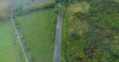 Hava atış alanları ve ormanları arasında bir tipik Avrupa ülkesi yol boyunca beyaz araba sürmek