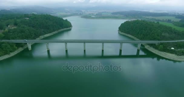 Aerial shot large bridge connects two islands in Tuscany, the movement of cars across the bridge across the pond — Stock Video