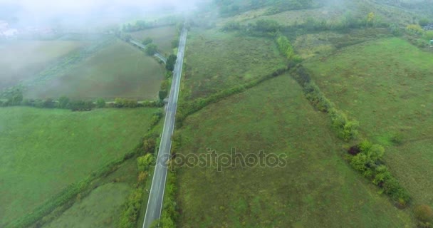 Landweg in Italië tijdens de mist. Luchtfoto schot, schieten in beweging vanuit helikopter, top uitzicht — Stockvideo