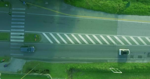 Luchtfoto shot auto verplaatsen langs de weg in de stad, fietser zit te wachten, een groen stoplicht signaal aan het oversteken van de rijbaan — Stockvideo
