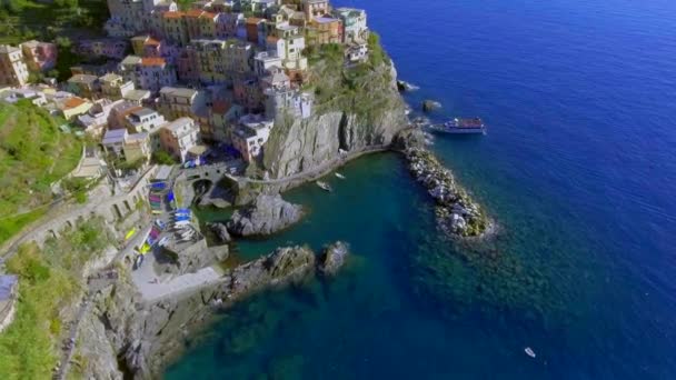 Antenn skott Manarola by på en klippa, branta klippor och blå havet i dagsljus, nationalparken Cinque Terre, Ligurien Italien Europa — Stockvideo