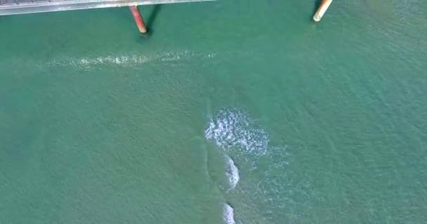 Caméra aérienne prise le long du front de mer merveilleux et jetée de la mer avec des touristes à pied 