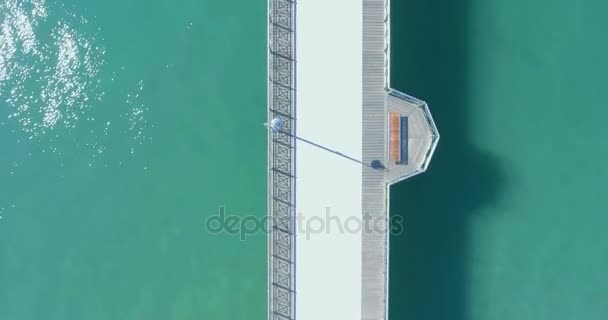 Voo de tiro aéreo sobre o cais do mar com turistas, vista de cima no cais no meio de um belo mar com água azul-turquesa — Vídeo de Stock