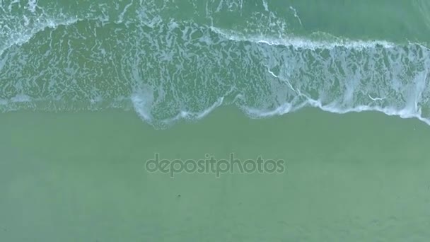 Vista superior ondas espumosas lavar tiro aéreo playa de arena, disparando desde el helicóptero — Vídeos de Stock