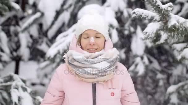 冬天的童话。美丽的女孩抛雪，雪花落在女人身上，在背景冷杉在雪地上，慢动作 — 图库视频影像
