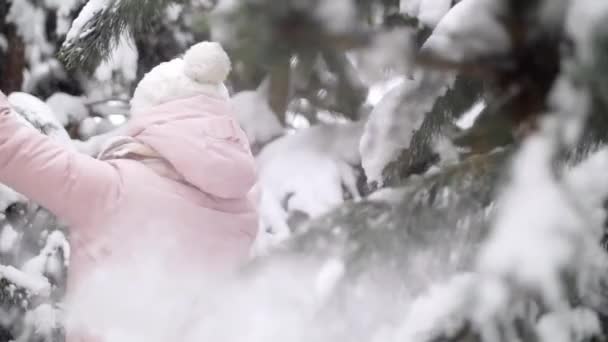 Веселая активная девушка наслаждается танцами в зимнем лесу среди елок замедленного движения — стоковое видео
